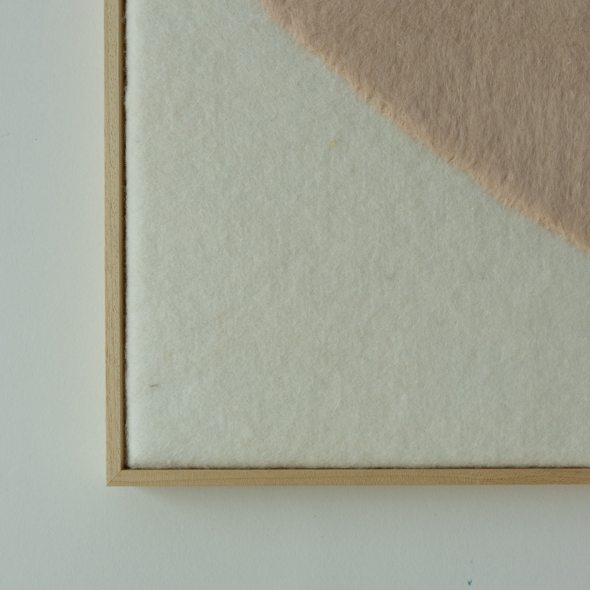 Detail van de lichte wolstructuur en beige vorm in het Stone wandkleed.