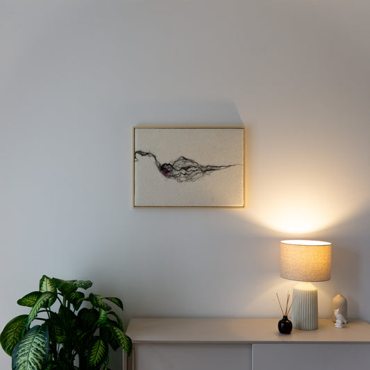 Wollen wandkleed Roots 03 in een rustig interieur met plant, lamp en licht houten meubel.