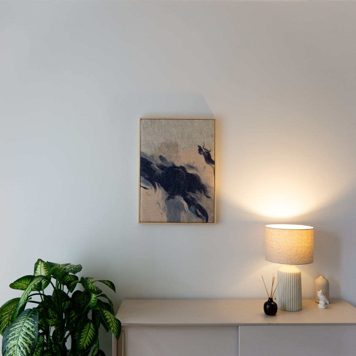 What time leaves behind 01 in een rustig interieur met plant, licht meubel en warme verlichting.