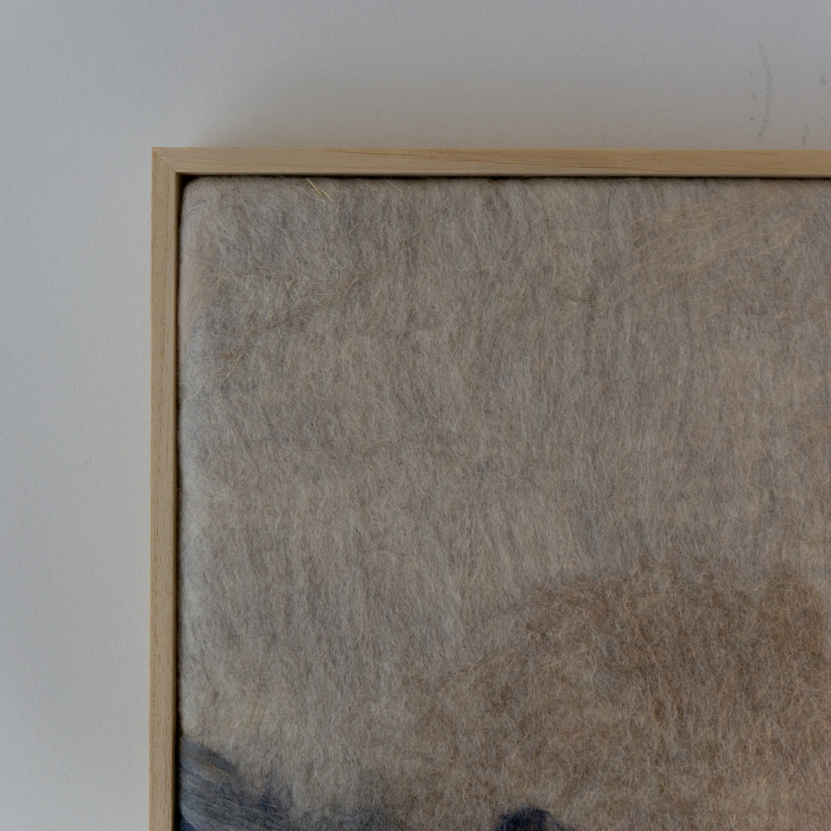Close-up van de zachte wolstructuur in beige, crème en blauwgrijs.